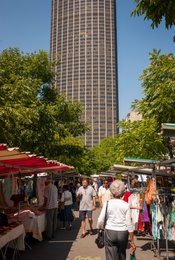 14th-arrondissement;-Boulevard-Edgar-Quinet;-Clothing-stall;-Daily-life;-Edgar-Quinet-market;-Kaleidos;-Kaleidos-images;-La-parole-à-limage;-Neighbourhood-market;-Paris;-Shoppers;-Stories-Pictures;-Striped-awning;-Summer;-Tarek-Charara;-Tour-Montparnasse;-Trees